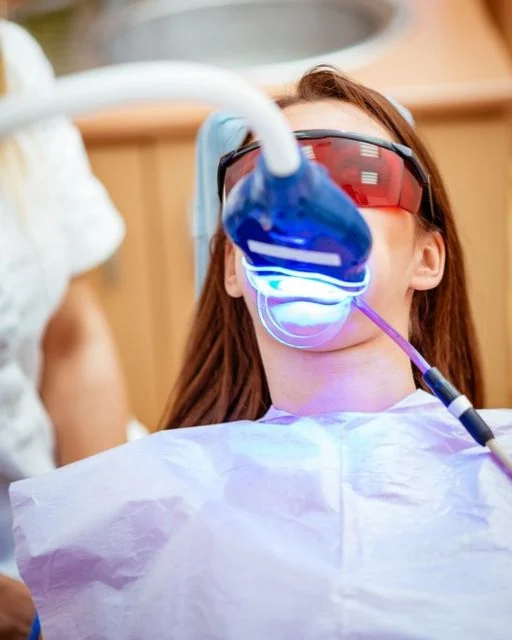 Paciente durante un blanqueamiento dental con luz LED