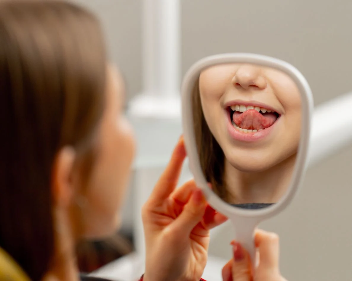 Paciente revisando sus dientes en un espejo